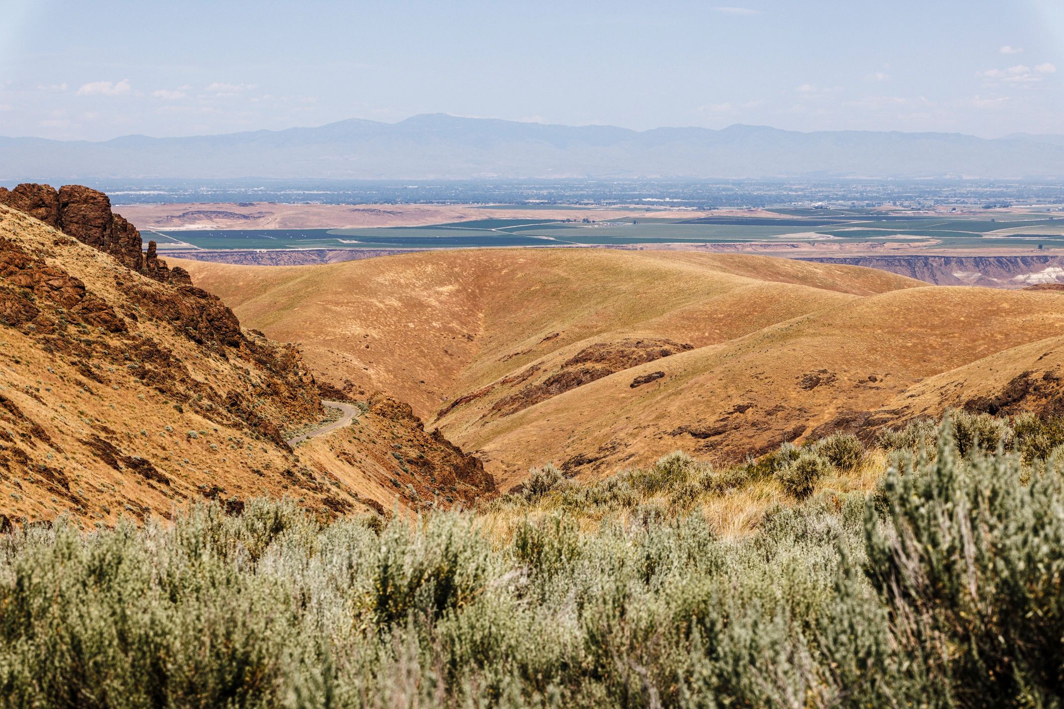 Rural Idaho farm landscape with open fields and distant agricultural valley